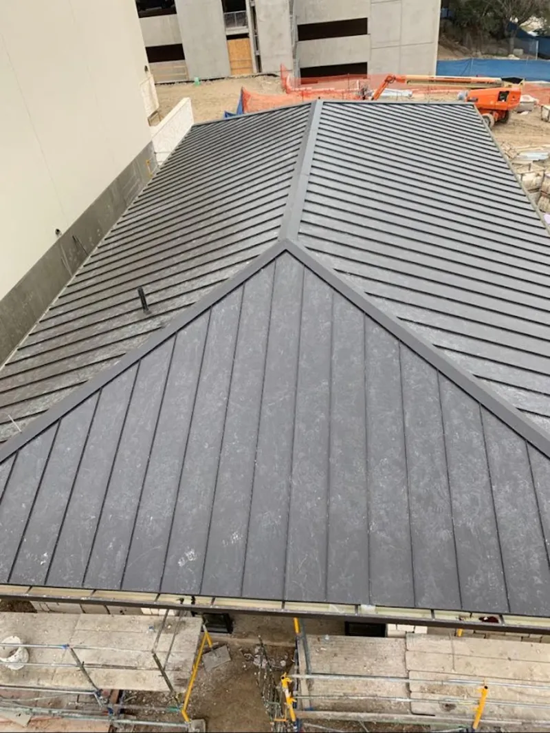 Commercial metal roof construction with crane equipment in Chardon