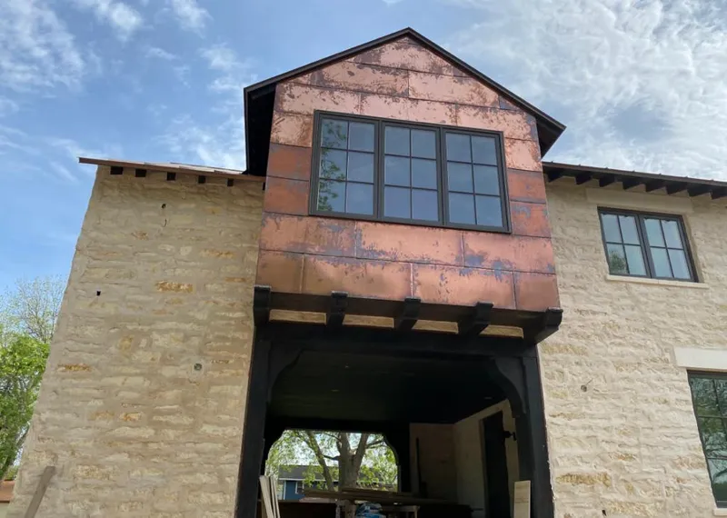 Copper metal panel facade on a stone building for Roof Repair in Chardon